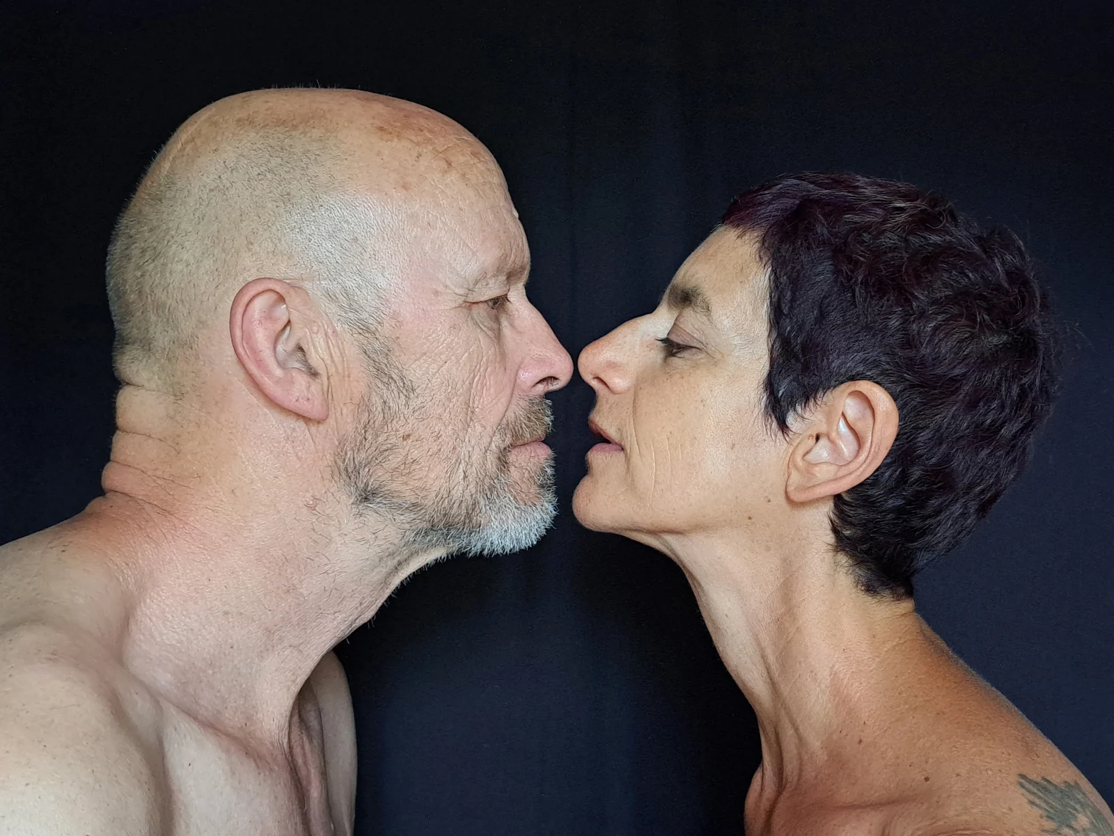 Henk Slomp et Gisèle Didi, de profil, se regardent sur un fond sombre.