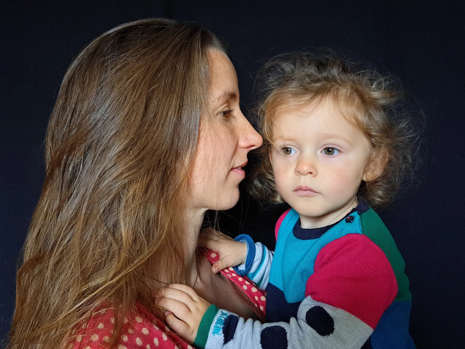 Clara et Maïna, une mère et son enfant, face à face sur fond noir